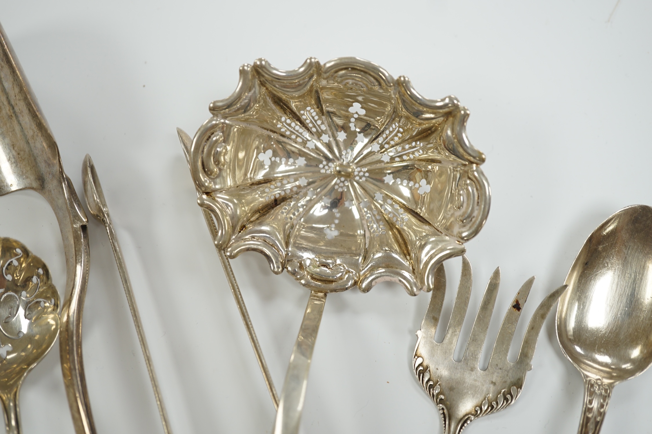A Victorian silver fiddle pattern stilton scoop, London, 1847, 21.5cm and six other items of sundry flatware including Dutch white metal sifter spoon, smaller silver sifter spoons and a pair of Georgian silver sugar tong